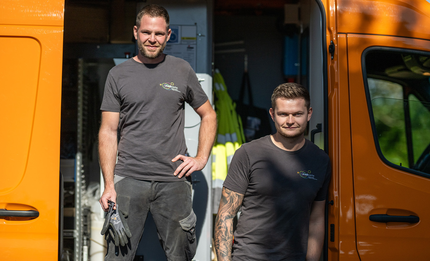 Die Mitarbeiter, der Stadtwerke Haltern am See, Joel und Daniel posieren in ihrem Arbeitsfahrzeug