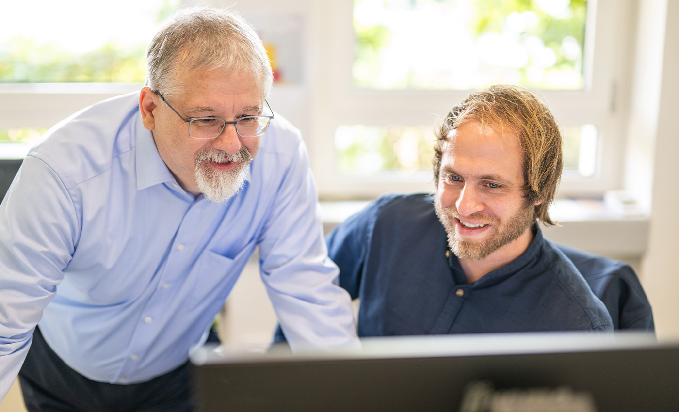 Christoph Lubahn und Markus Spree, aus der Abteilung Kundenservice, betrachten einen Computer-Bildschirm